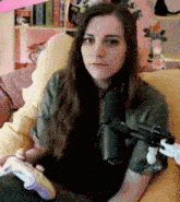 a woman sits on a couch with a microphone and a controller