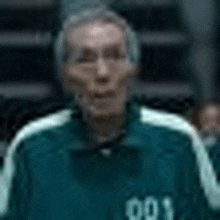 a man wearing a green and white jacket with the number 991 on the back .