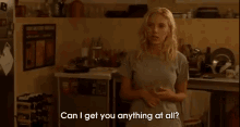 a woman standing in a kitchen with the words can i get you anything at all below her
