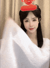 a young woman with a stuffed animal on her head .