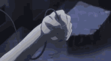 a close up of a person 's fist holding a cord in their hand .