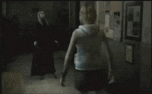 a woman in a white tank top is standing in front of a man in a red robe and says so what ..
