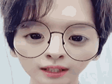 a close up of a person 's face wearing glasses