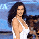 a woman wearing a white swimsuit with the word flair on the front