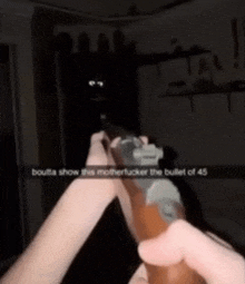 a person holding a gun with a caption that says " boutta show this motherfucker the bullet of 45 "