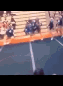 a blurred image of cheerleaders jumping on a trampoline