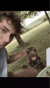 a man is petting a dog while taking a picture of himself .