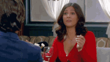 a woman in a red top is sitting at a table with a man in a blue suit