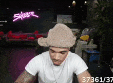 a man wearing a furry hat with the number 37361 on the bottom right