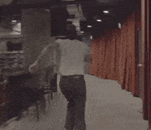 a man in a baseball cap is running down stairs in a hallway .