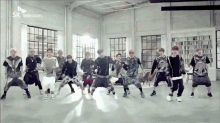 a group of young men are dancing in a room with a sk telecom logo in the background