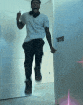 a man in a white shirt is jumping in the air and giving the middle finger