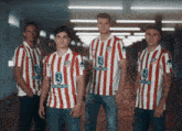 a group of soccer players wearing red and white striped shirts with the number 3 on them