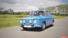 a blue car is driving down a road with a thinkiules logo in the corner
