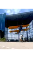 a yellow and blue u.s. airplane hangs from the ceiling of a building