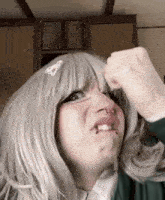 a woman wearing a wig is making a funny face .