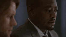 a man in a suit says " which means " in white letters