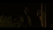 a woman without a shirt is standing in the dark in a dark room looking at the camera .