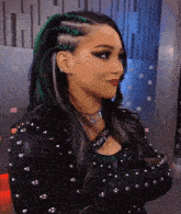 a woman in a black jacket with studs on it