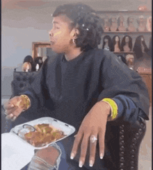 a woman is sitting at a table with a tray of food in front of her .