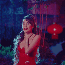 a woman in a red dress is singing in front of a chinese lantern