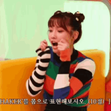 a girl in a striped sweater is making a funny face in korean