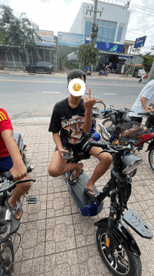 a boy wearing a shirt that says saigon sits on a scooter