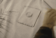 a close up of a person 's hand holding a piece of fabric .