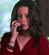 a woman with a tattoo on her wrist is talking on her cell phone