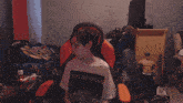 a young boy wearing a beatles shirt sits in a chair