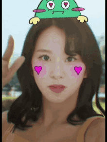 a girl with a green monster on her head and pink hearts on her cheeks