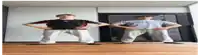 two dolls are standing next to each other with their hands on their hips in front of a mirror .