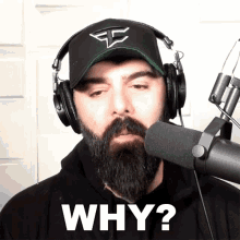 a man with a beard wearing headphones and a hat is asking why