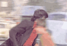 a blurry picture of a man in a suit and a red shirt