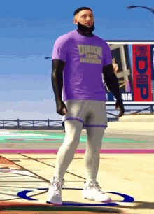 a man wearing a purple t-shirt that says titans on it is standing on a basketball court