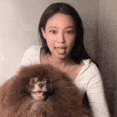 a woman sticking her tongue out while holding a dog