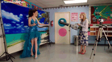 a woman in a blue dress is being photographed by a teacher in a classroom with the hashtag #teachersseries