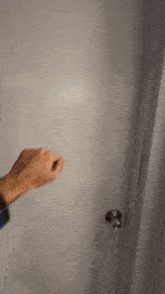 a person is opening a door with a silver door knob .