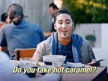 a man sitting at a table with the words " do you take hot caramel " below him
