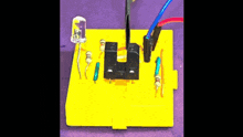 a yellow box with electronics on it including a light bulb and resistors