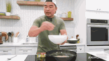 a man is preparing food in a kitchen while holding a bowl .