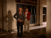a man and woman are walking in front of a razorbacks sign