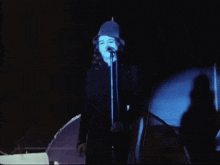 a woman is singing into a microphone on stage