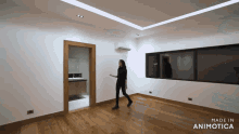 a woman walking in an empty room with the words made in animotica below her