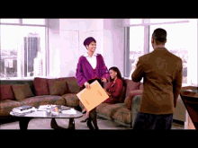 a woman in a purple jacket is holding an envelope that says ' i 'm sorry ' on it