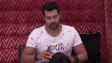 a man wearing a white shirt that says your