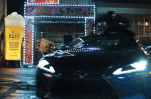 a car is driving past a building with a sign that says ' ice cream ' on it