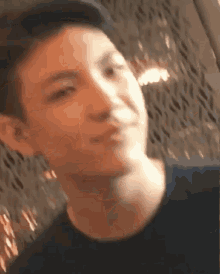 a close up of a young man 's face with a blurry background .