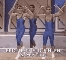 three men in blue overalls are dancing together in a room .