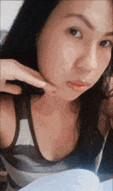 a woman is taking a selfie with her hand on her neck